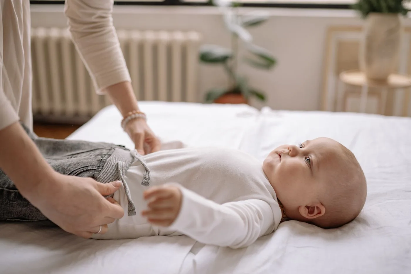 Un adulte prépare l’habillement du bébé, avant les autres moments du soir.